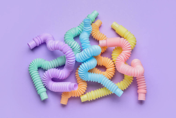 Διαφορετικές πολύχρωμες σωλήνες Pop σε μωβ φόντο - Φωτογραφία, εικόνα