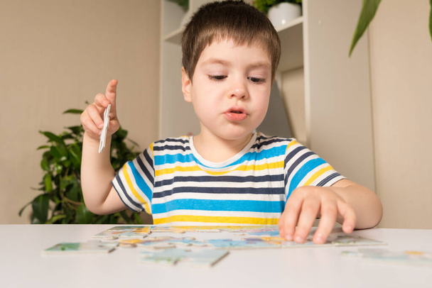 Un enfant d'âge préscolaire joue des énigmes, rassemble une image - Photo, image