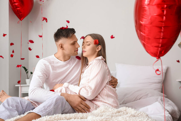 Happy couple celebrating Valentine's Day in bedroom at home - 写真・画像