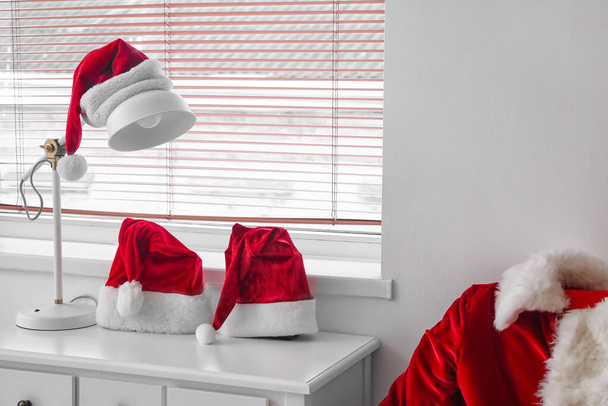 Санта-капелюхи з лампою на столі в кімнаті
 - Фото, зображення