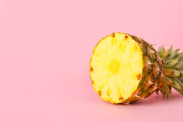 Half of ripe pineapple on pink background - Valokuva, kuva