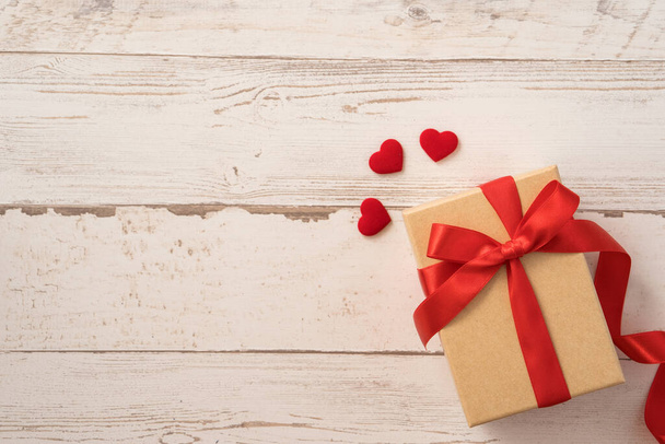 Top view of kraft gift box with red ribbon bow for Valentine day. - Zdjęcie, obraz