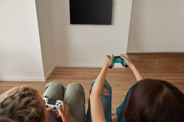 Cropped image of lesbian girls playing video game - Фото, изображение