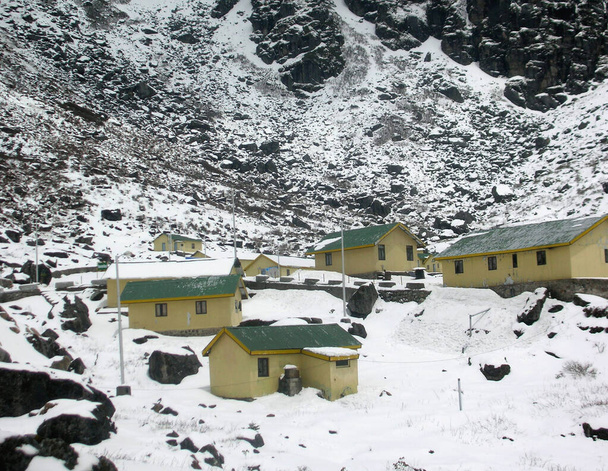 Sikkim 'deki Nathula sınırı yakınlarındaki Sherathang Mart' ta karla kaplı evlerin ve arazinin panoramik görüntüsü. Ticaret pazarı, Hindistan ile Çin arasındaki ticaret için Temmuz 2006 'da açıldı ve kış boyunca kapalı kaldı.. - Fotoğraf, Görsel