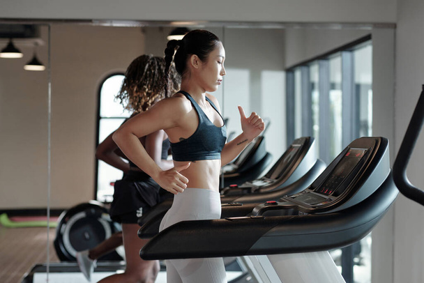 Young Woman Jogging on Treadmill - Photo, Image