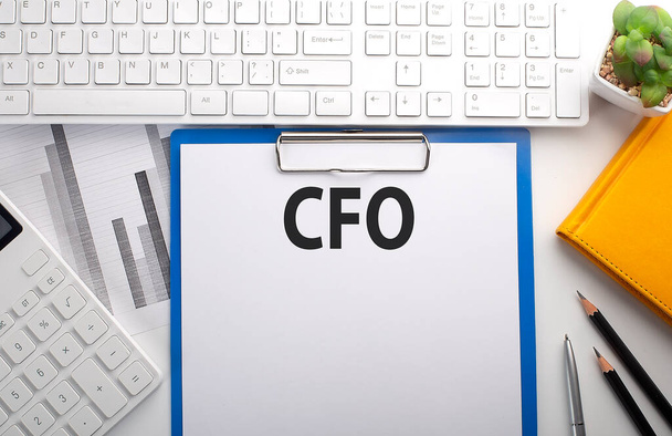 CFO napsaný na papíře s klávesnicí, grafem, kalkulačkou a notebookem - Fotografie, Obrázek