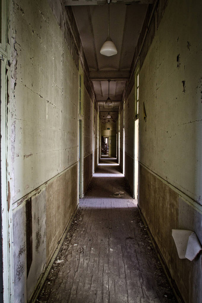 A vertical shot of a creepy corridor in an abandoned house - Фото, изображение