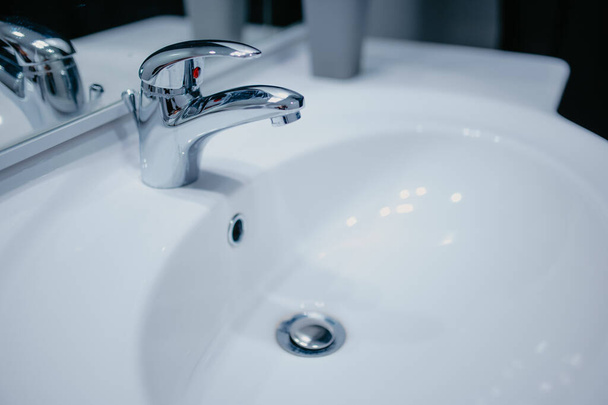 A ceramic sink with a metallic tap in the bathroom - Foto, immagini