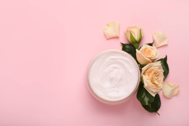 Jar of body cream with rose flowers on light pink background, flat lay. Space for text - Foto, Imagen