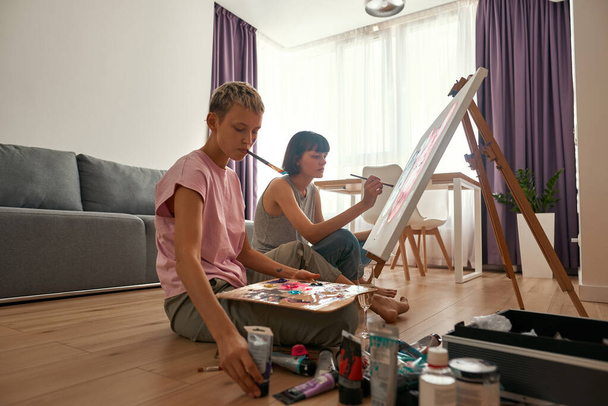 Young lesbian girls paint picture of mouse faces - 写真・画像