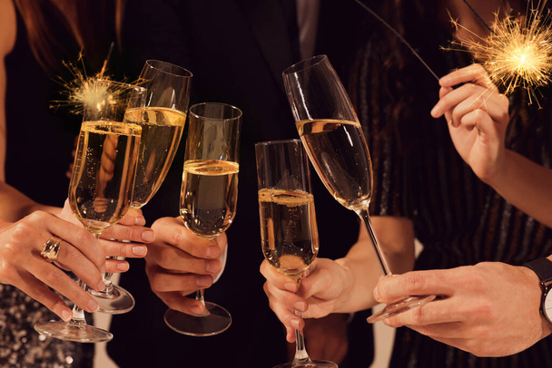 Friends clinking glasses of sparkling wine, closeup. New Year celebration - Foto, imagen