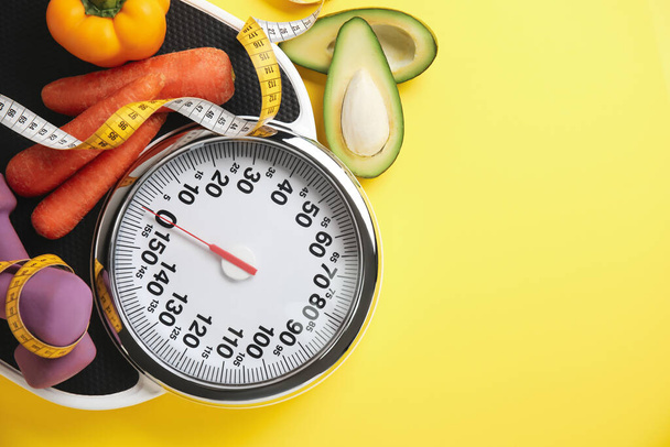 Flat lay composition with scales and vegetables on yellow background, space for text - Foto, afbeelding