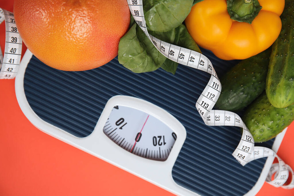 Scales, healthy food and measuring tape on orange background, top view - Photo, image