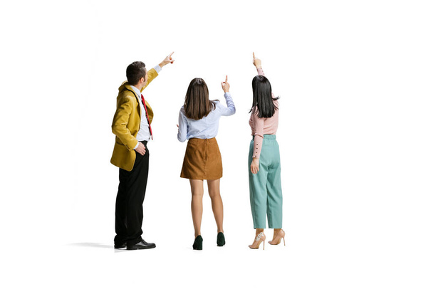 Portrait complet de trois employés, travailleur pointant vers le haut isolé sur fond blanc - Photo, image