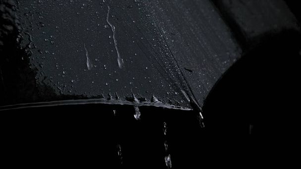 Φωτογραφία από μαύρη υγρή ομπρέλα και βροχερές σταγόνες - Φωτογραφία, εικόνα