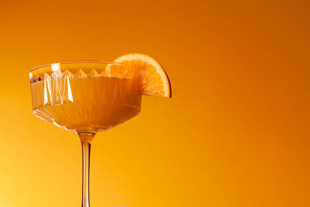 Glass of vegan fruit alcohol free mimosa cocktail. Refreshing festive orange mocktail - Fotó, kép