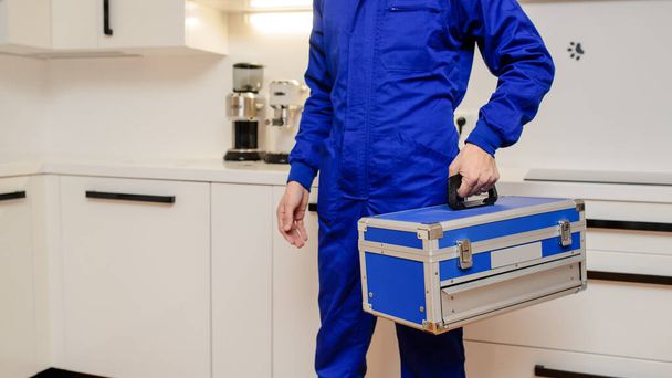 Close up  man plumber holding toolbox in the kitchen a prepare for work - Photo, Image