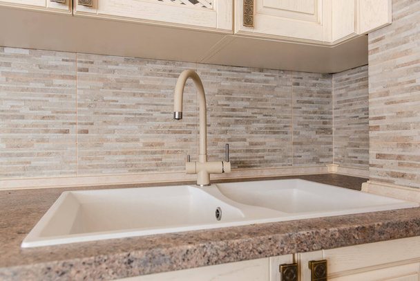 Close up dishwasher sink and water tap made from stone in vintage wood kitchen - Foto, imagen