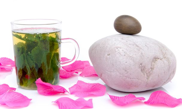 Composição com uma xícara de chá de hortelã, seixos e pétalas rosa
 - Foto, Imagem