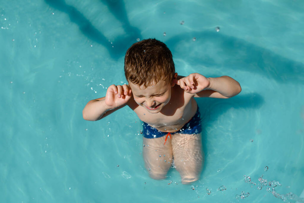 Top view of a boy kid playing in the swimming pool and closed the eyes - Φωτογραφία, εικόνα