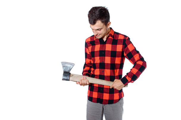 Young man in checkered shirt woodcutter holding an axe and smile isolated on white background - 写真・画像