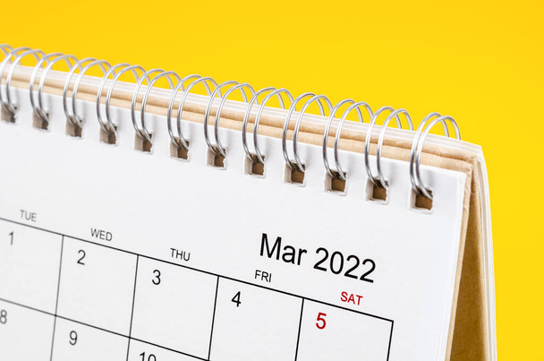 黄色の背景に2022年3月のデスクカレンダーを閉じる. - 写真・画像