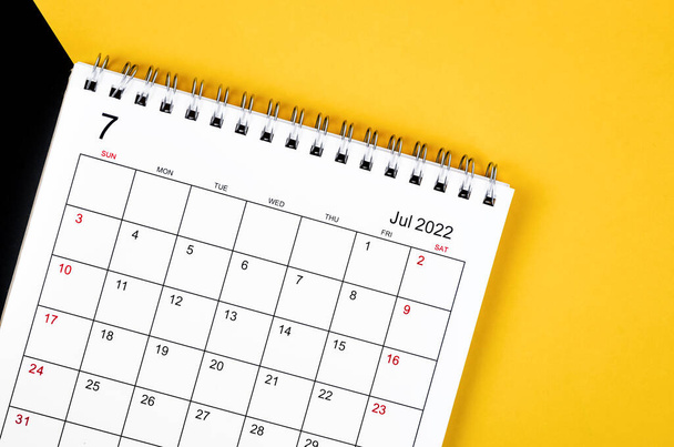 The July 2022 desk calendar on yellow and black background. - Fotó, kép