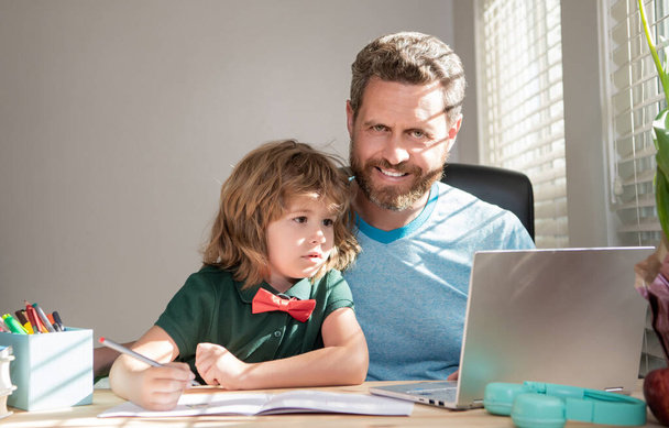 bärtiger Vater oder Privatlehrer, der Sohn mit modernem Laptop unterrichtet, Hausaufgabenbetreuung - Foto, Bild