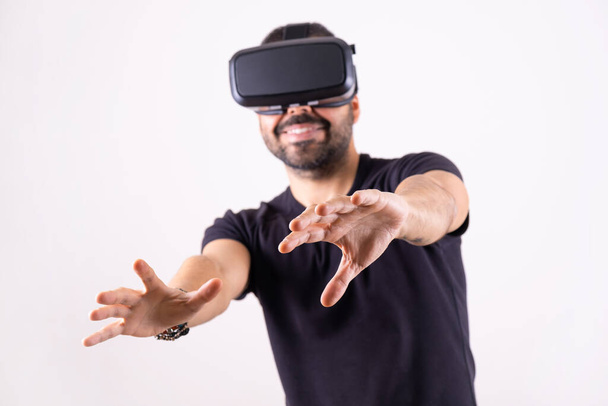 Een jongeman met een VR-bril die portret gebaart. Virtual reality, toekomstige technologie, educatie video gaming - Foto, afbeelding