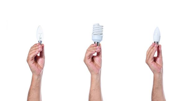 Hands holding classic tungsten incandescent light bulb, fluorescent light bulb, and led eco bulb. The history of evolution of light bulbs on white background isolated - Zdjęcie, obraz