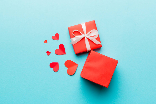 Joyeux jour de la Saint-Valentin ouvert boîte cadeau en forme de coeur avec de petits coeurs, sur fond coloré, carte de Saint-Valentin concept vue du dessus. - Photo, image