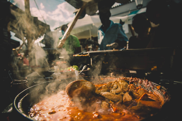 Cheff serviert internationale Fusion-Küche am Straßenstand auf dem internationalen Streetfood-Festival Odprta kuhna, Open kitchen event, in Ljubljana, Slowenien - Foto, Bild