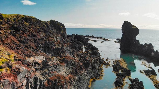 Słynne formacje skalne Reynisdrangar na czarnej plaży Reynisfjara. Wybrzeże Oceanu Atlantyckiego w pobliżu Vik, południowa Islandia w sezonie letnim z drona. - Zdjęcie, obraz