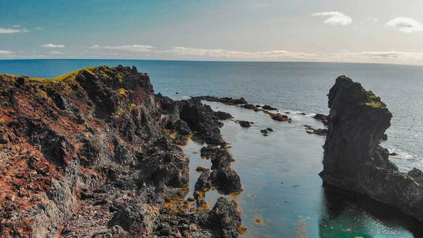 Famous Reynisdrangar rock formations at black Reynisfjara Beach. Coast of the Atlantic ocean near Vik, southern Iceland in summer season from drone. - Photo, Image