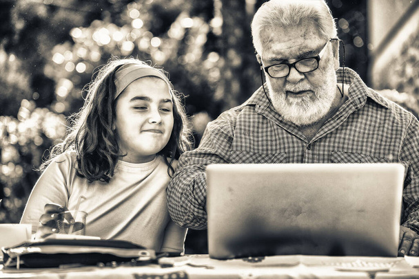 Abuelo explica cómo utilizar el ordenador portátil a su nieta - Foto, Imagen