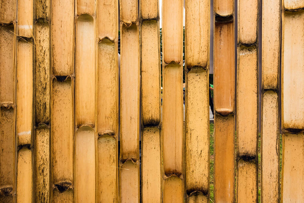 Pared simple de bambú de tono marrón antiguo o fondo de textura de valla de bambú para el diseño interior o exterior tono vintage. Fondo de patrón de palo de bambú marrón. Área local protección de la casa urbana contra ladrón. - Foto, imagen