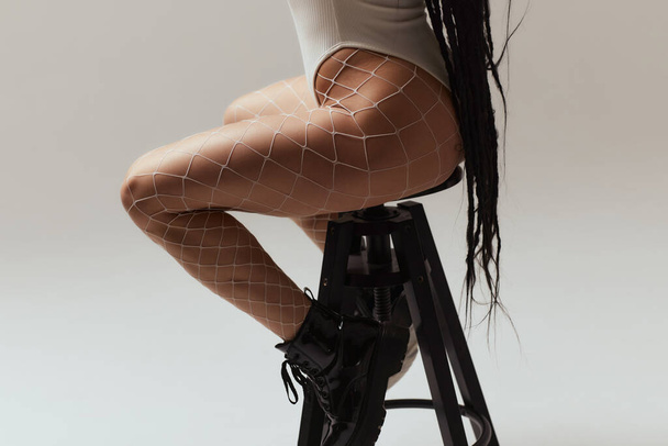 Close-up of woman feet with fishnet tights isolated on white background. - 写真・画像