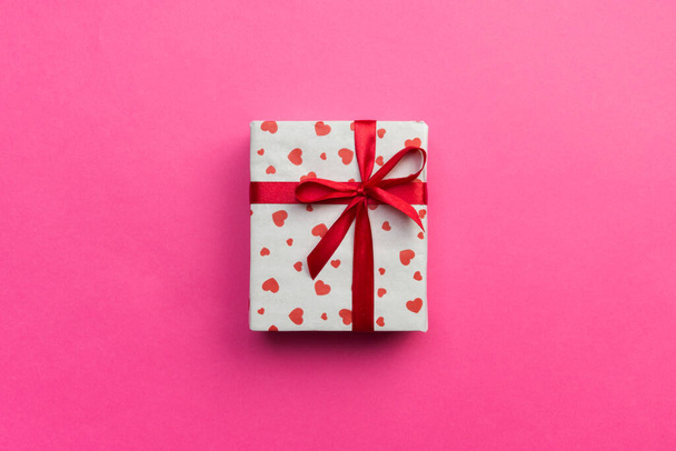 Ιστορικό με κουτί δώρου και καρδιές σε ροζ φόντο. Κάτοψη με χώρο αντιγραφής για κείμενο. - Φωτογραφία, εικόνα
