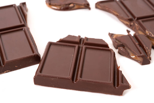 Dark chocolate bar and cubes with cream filling inside. Selective focus - Fotoğraf, Görsel