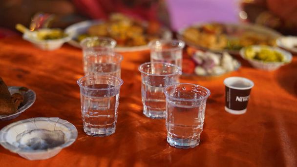 21 Νοεμβρίου 2021 Reengus, Rajasthan, Ινδία. Νερό σε πλαστικό ή γυαλί απόρριψης στο τραπέζι σε γαμήλιο πάρτι. Ινδική ακριβή έννοια του γάμου. - Φωτογραφία, εικόνα
