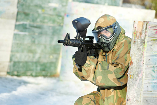 paintball player with marker at winter outdoors - Photo, Image