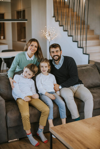 Happy young family with two kids enjoy time together on couch in living room - Φωτογραφία, εικόνα