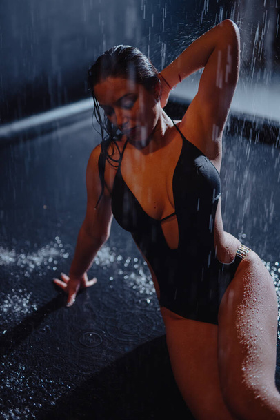Woman in bikini sitting in aqua studio under rain drops - Foto, immagini