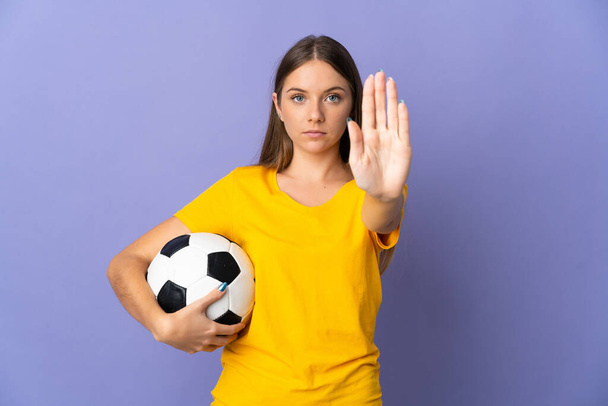 Молодая литовская футболистка, изолированная на фиолетовом фоне - Фото, изображение