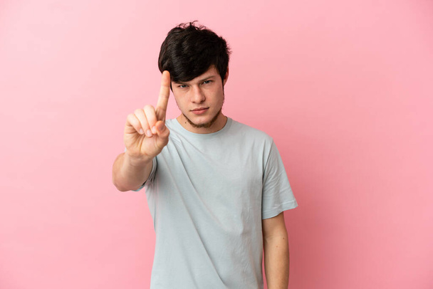Young Russian man isolated on pink background counting one with serious expression - Photo, Image