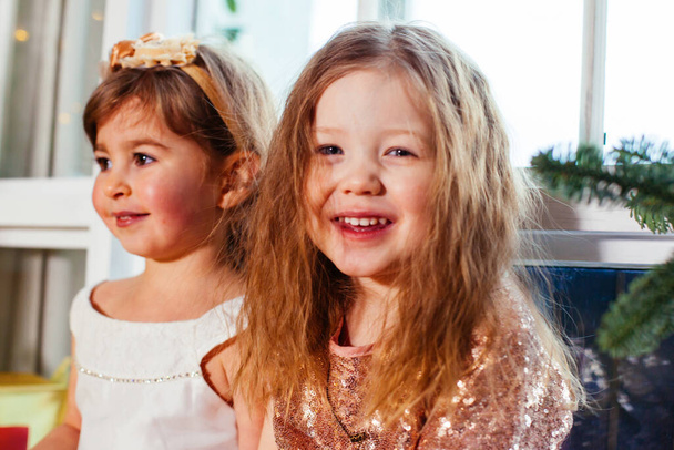 Noel ağacının yanında iki küçük kız arkadaş var. - Fotoğraf, Görsel