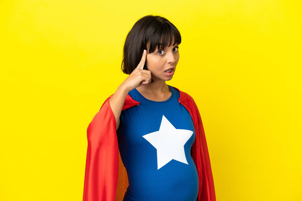 Super Hero raskaana oleva nainen eristetty keltaisella taustalla ajattelu idea - Valokuva, kuva