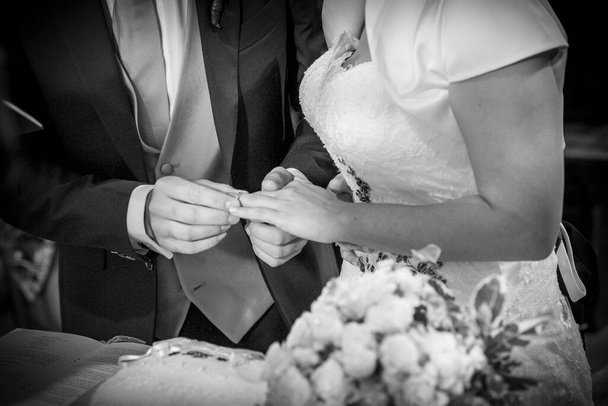 bruid zet trouwring aan bruidegom in katholieke rite in Italië. Hoge kwaliteit foto - Foto, afbeelding