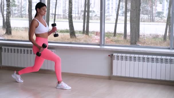 Athletic girl lunges against a big window - Footage, Video