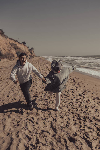 Man and woman enjoy each other, run along the seashore - Fotó, kép
